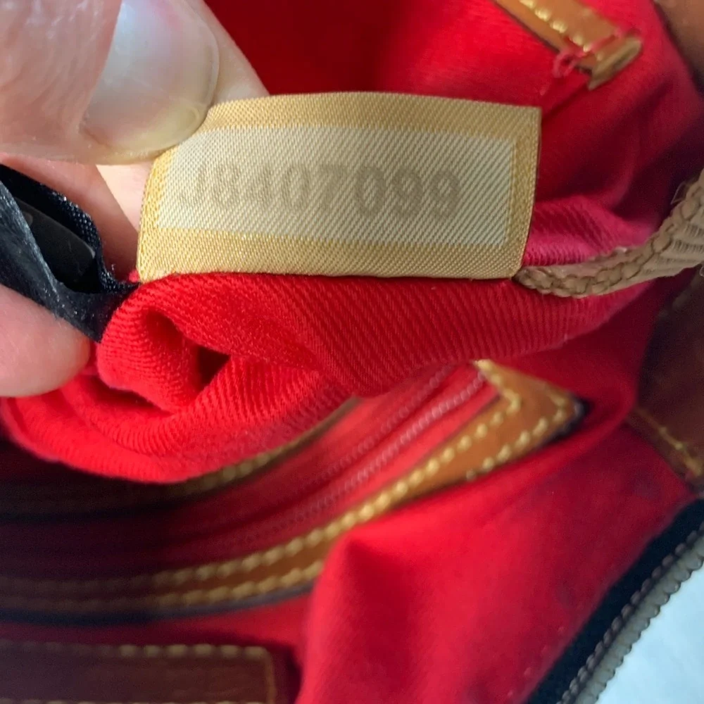 Dooney & Bourke black nylon crossbody bag with brown leather strap and accents